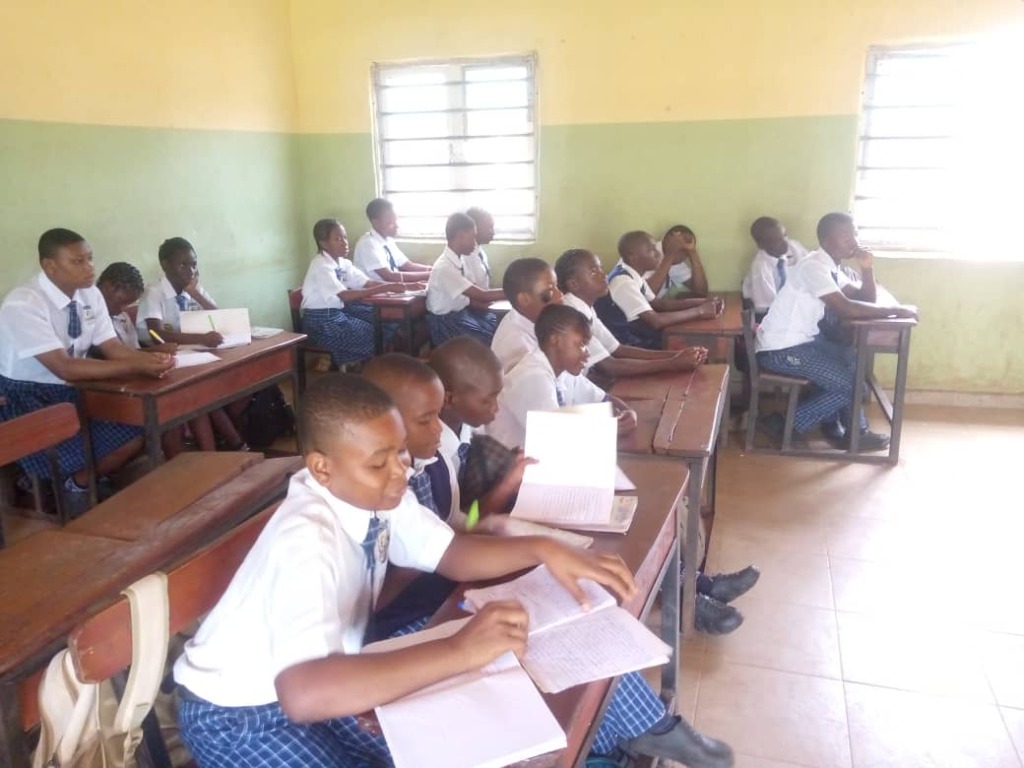 Students engaged in focused classroom study with books and official uniforms